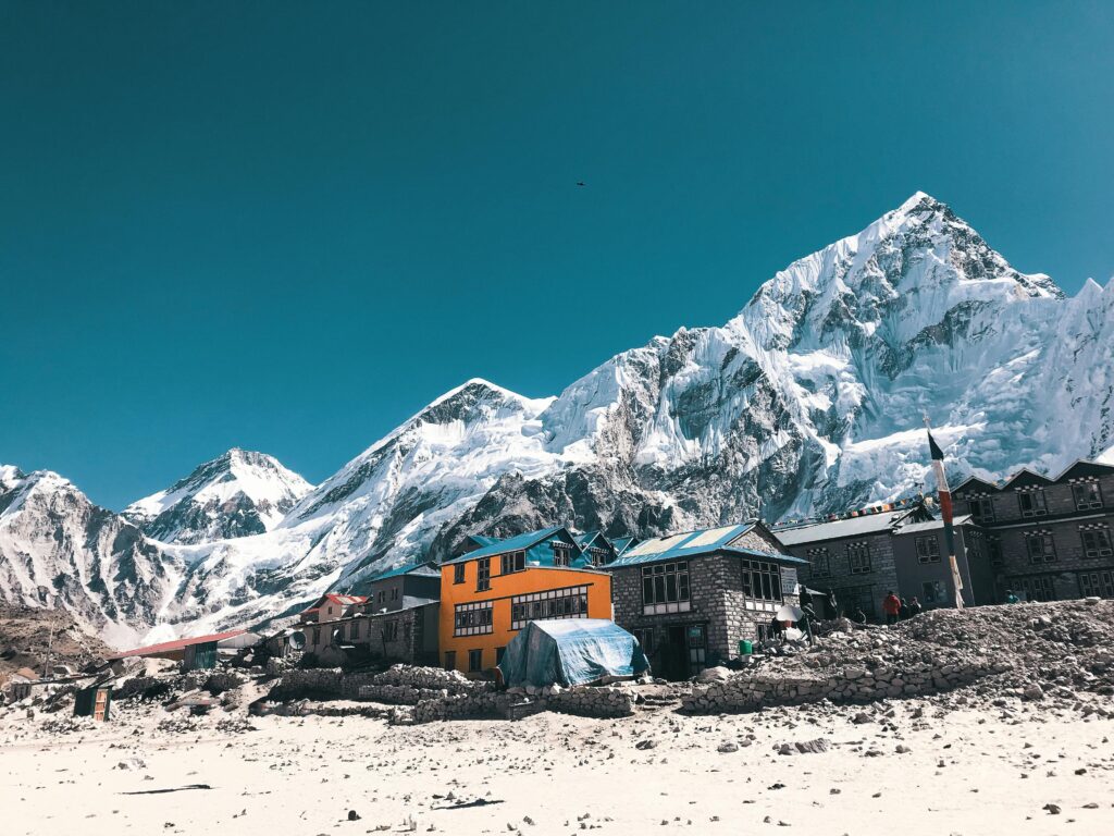 Vibrant houses beneath the majestic snow-capped peaks of the Himalayas in Khumjung, Nepal.
